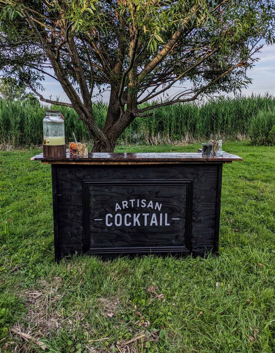 Bar mobile Artisan Cocktail installé sous un saule pour un mariage